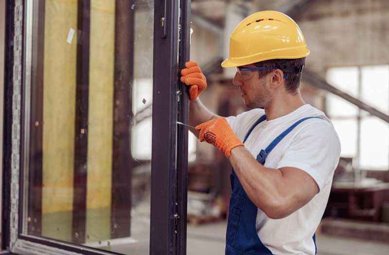 Locksmith repairing window locking mechanism